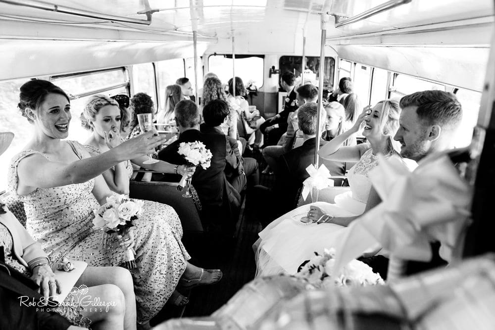 Bride, groom and wedding party on double decker bus