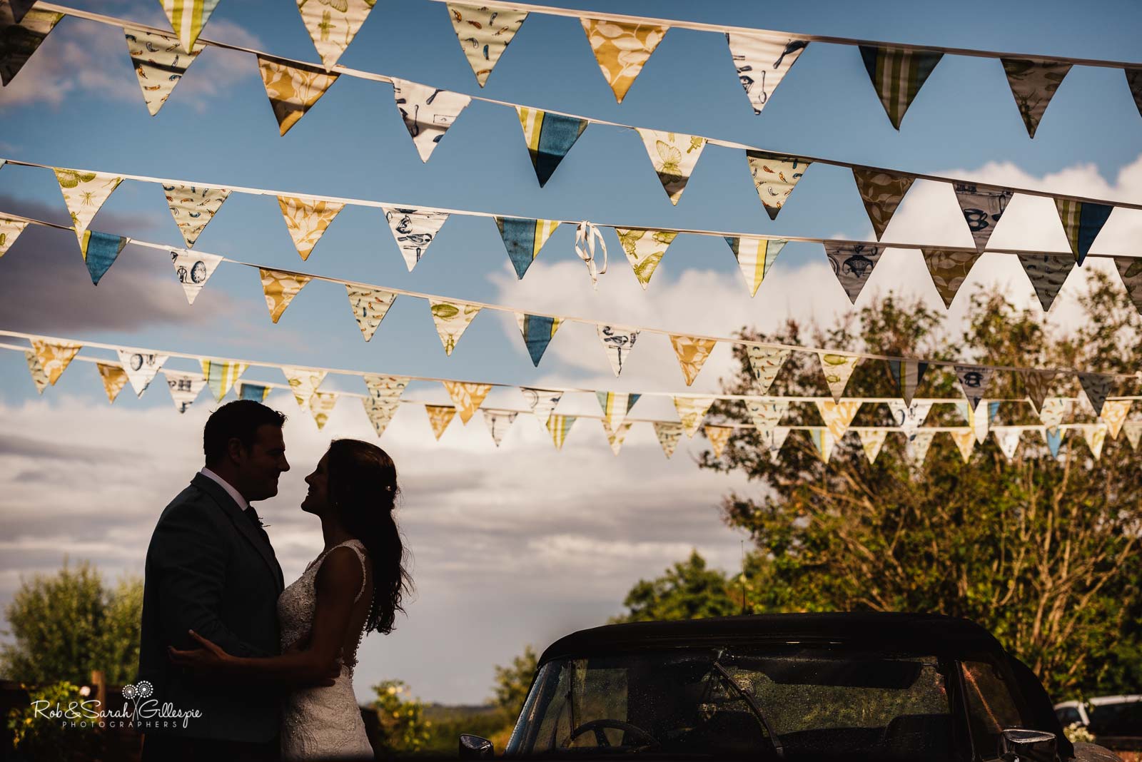 Bride and groom under bunting at Wethele Manor