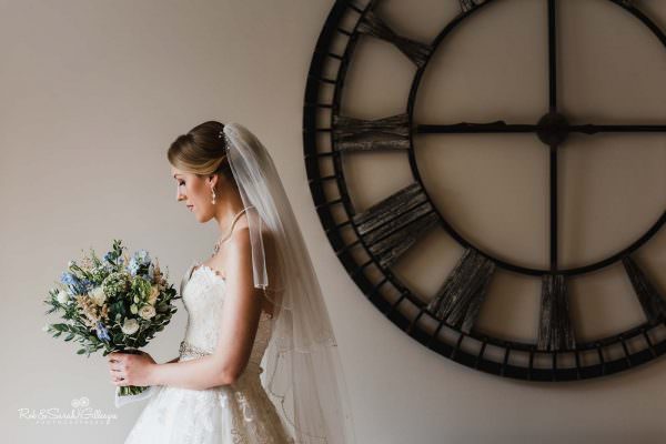 Beautiful portrait of bride at The Mill Barns with large clock on wall