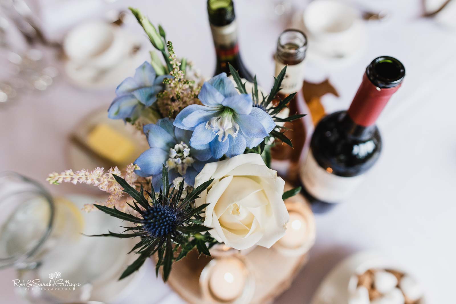 Wedding breakfast details with flowersand wine bottles