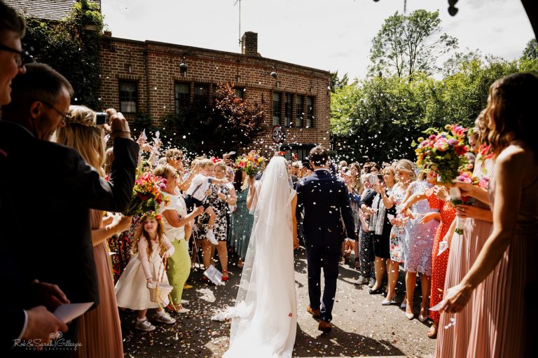 Bride and Groom have confetti thrown by guests at St Leonard's Church Clent