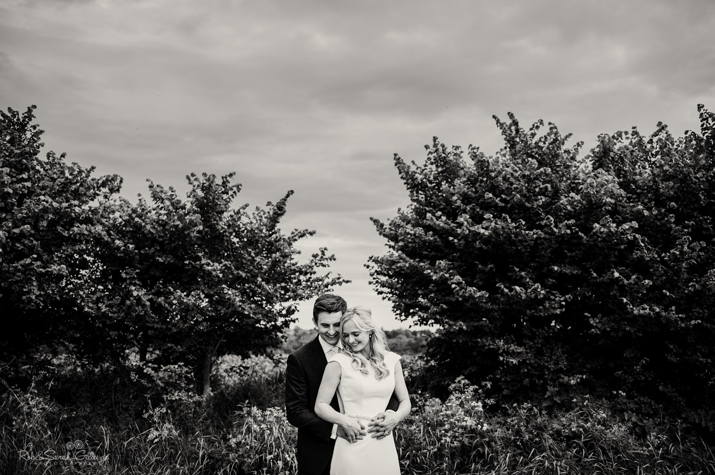 Bride and groom in field at village hall wedding