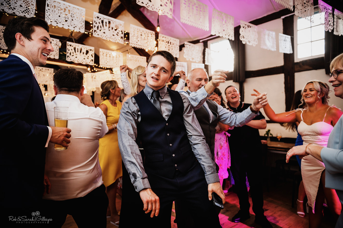 Guests dancing at village hall wedding reception