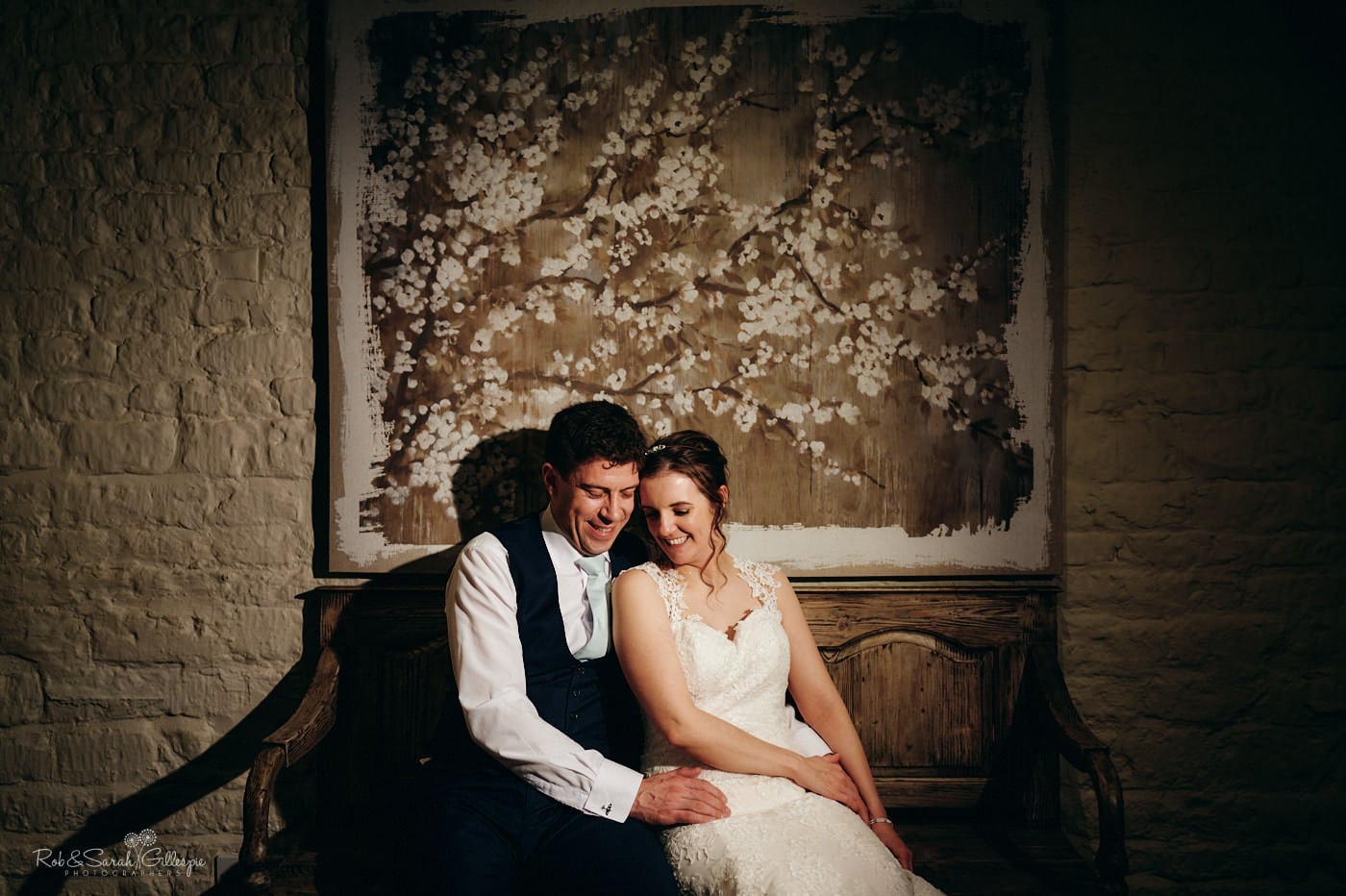 Bride and groom seated together in beautiful barn venue