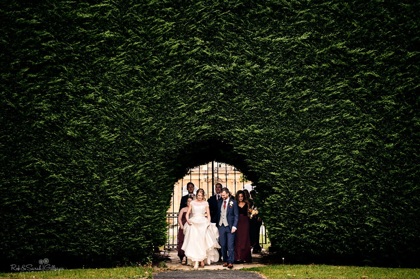 Bride, groom and bridal party walk through grounds at Spring Grove House