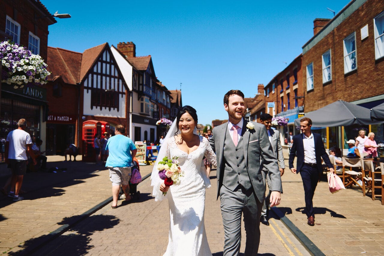 Bride & Groom walking through Stratford after wedding at The Henley Room