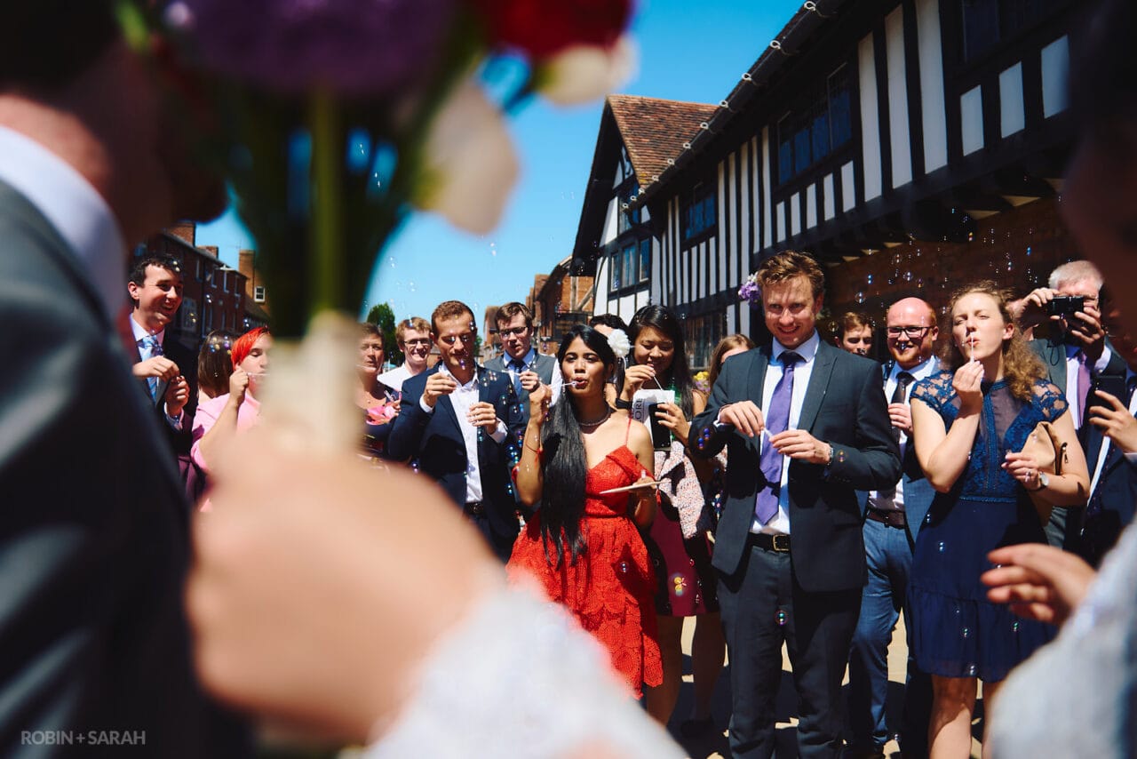 Wedding guests blow bubbles after ceremony at The Henley Room