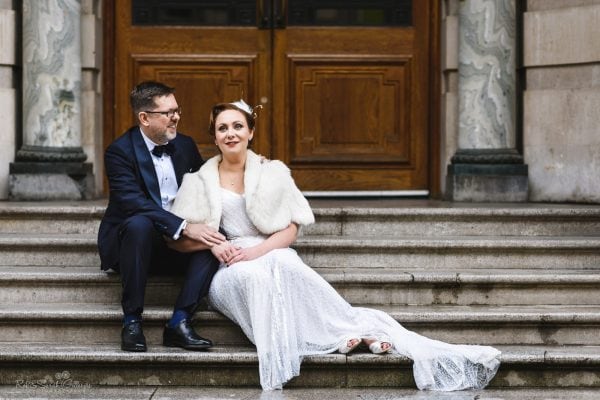 Bride and groom sitting on stone steps in Birmingham city centre