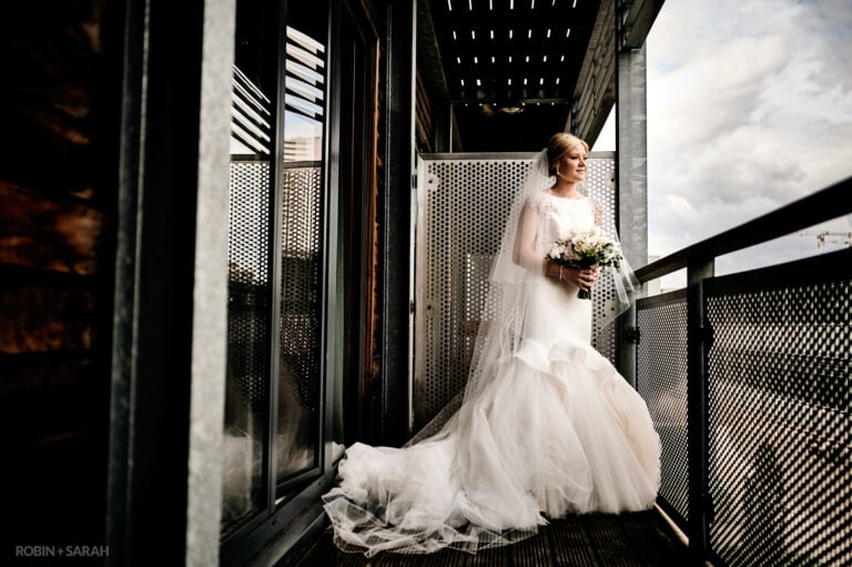 Portrait of bride standing on outside balcony