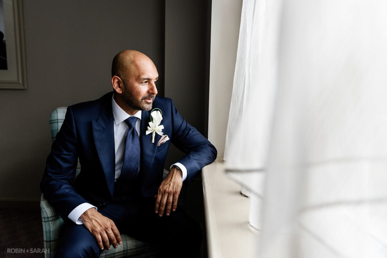 Portrait of groom sitting in window light