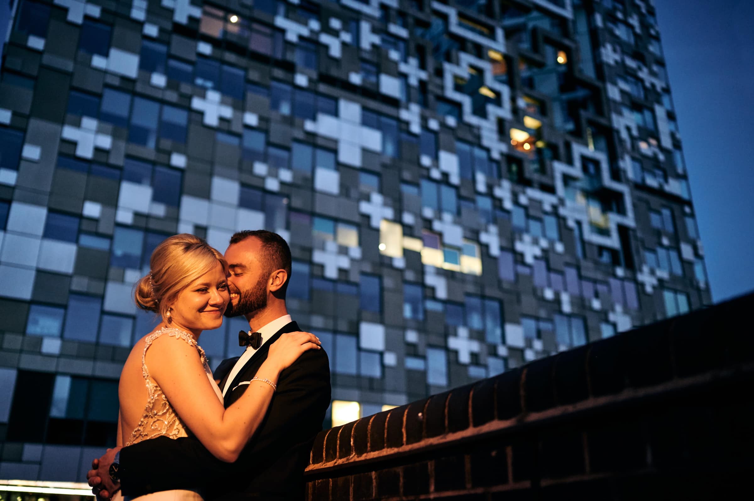 Bride and groom cuddled up at The Cube in Birmingham, at night