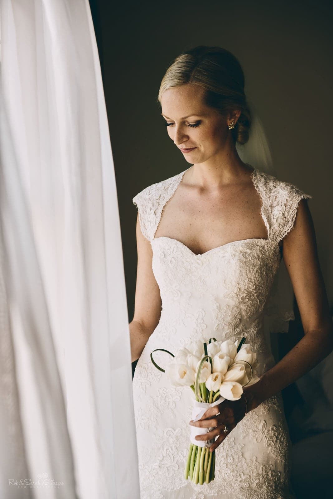 Beautiful bride portrait in window light as curtain billows