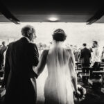 Dad glances at daughter as they walk up aisle for wedding ceremony