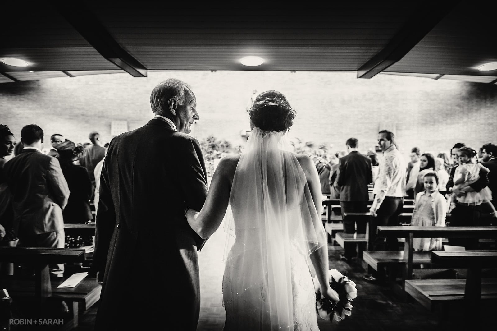 Dad glances at daughter as they walk up aisle for wedding ceremony
