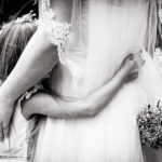 Flowergirl hugs bride