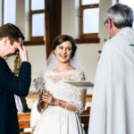 Bride laughing as groom messes up his vows in church wedding ceremony