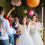 Two brides run up aisle as confetti is thrown over them