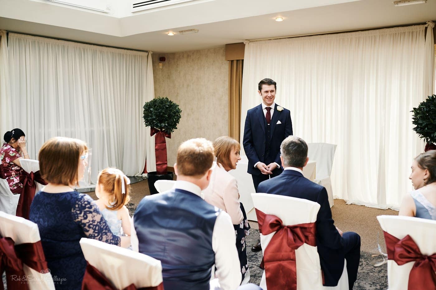 Groom chats to guests before wedding ceremony