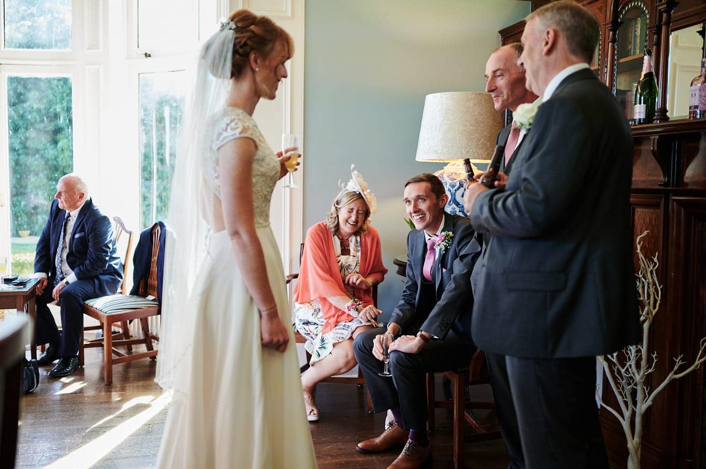 Wedding guests chat and laugh during small wedding drinks reception