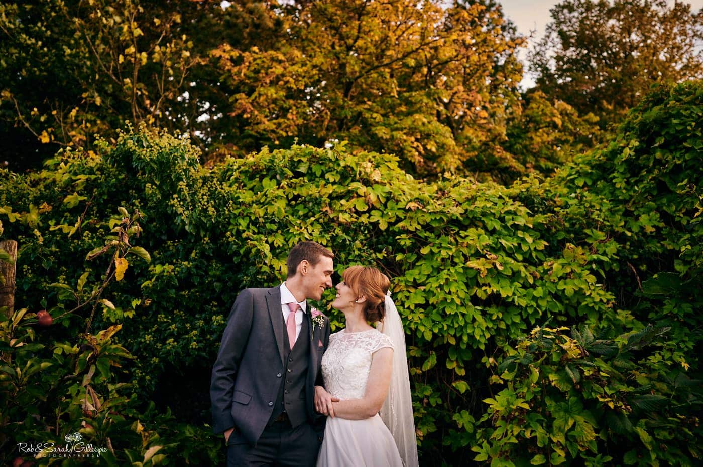 Bride and groom laughing together in grounds at Pendrell Hall 