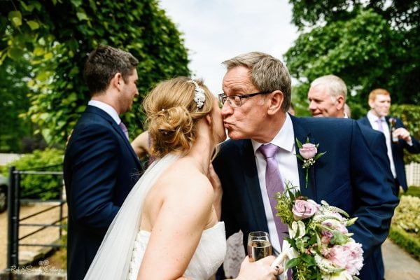 Bride and guest kiss after wedding ceremony