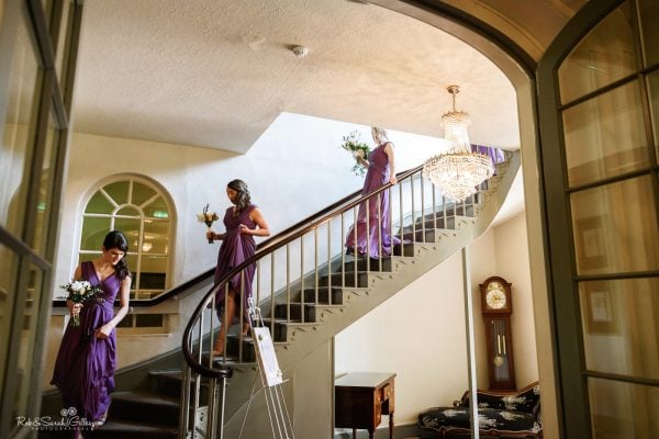 Bridesmaids walk down staircase at Warwick House
