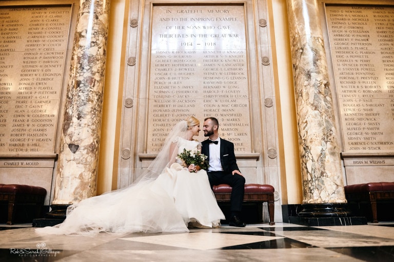 Bride and groom sitting in grand hall at Birmingham University