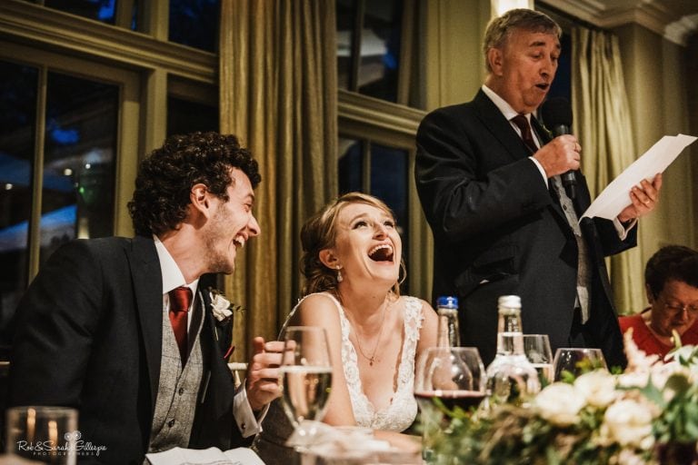 Bride and groom laughing during wedding speeches
