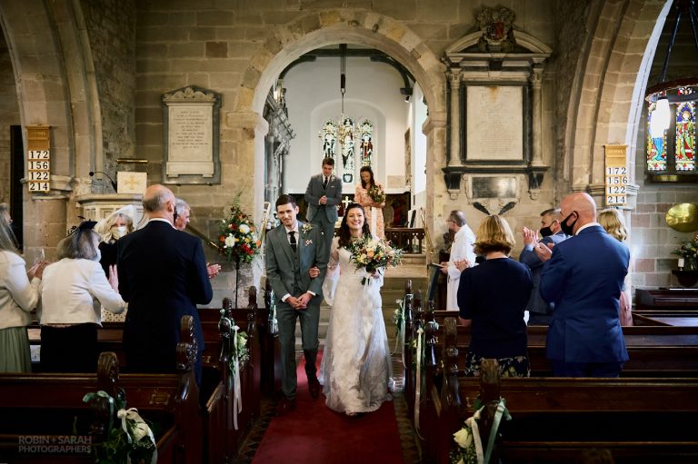 Bride and groom down aisle after wedding ceremony at St Leonard's Beoley