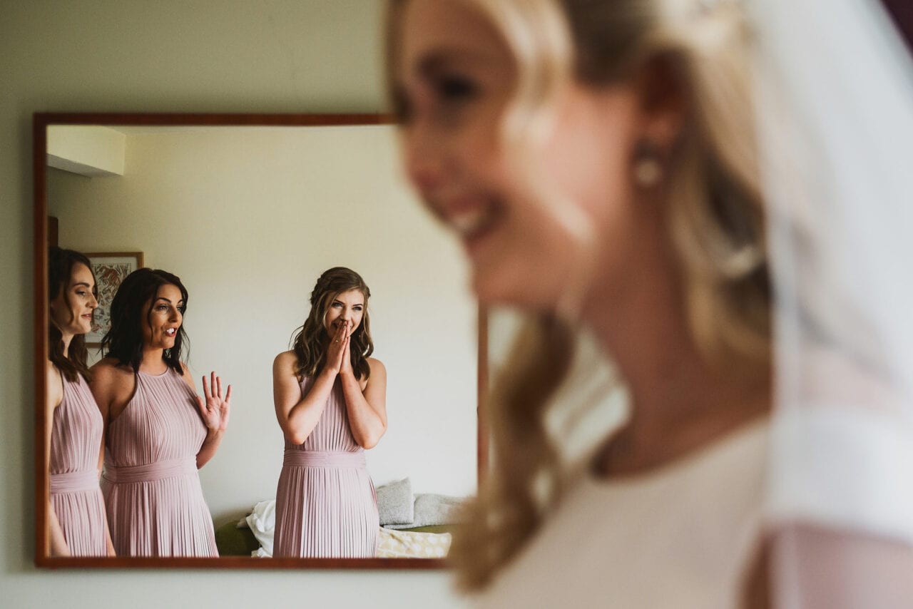 Bridesmaids react to seeing bride in wedding dress