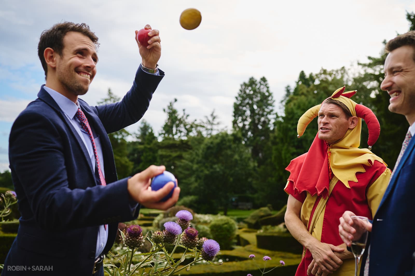 Wedding guests juggles balls as court jester watches
