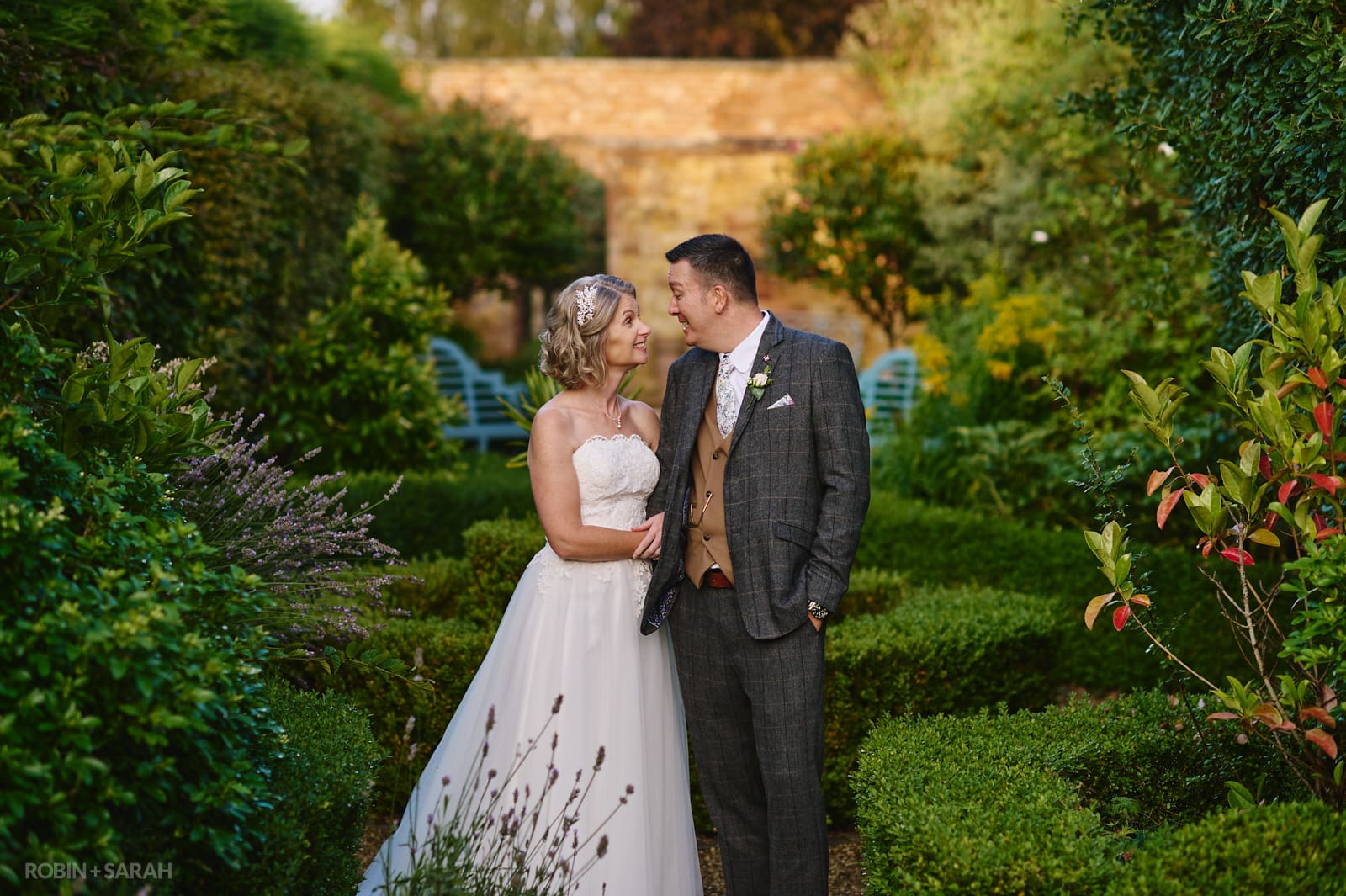 Bride and groom in grounds at wedding venue in beautiful evening light