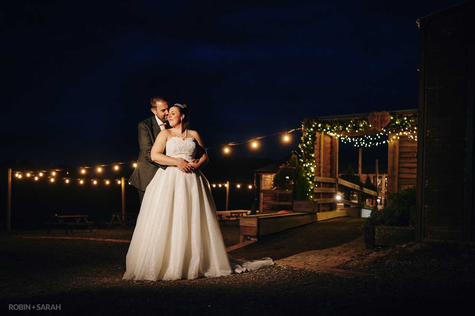 Bride and groom at night outside barn wedding venue