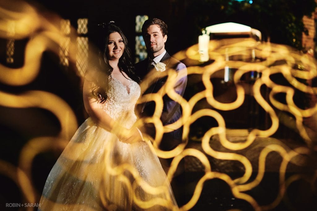 Bride and groom outside at night with decorative lights