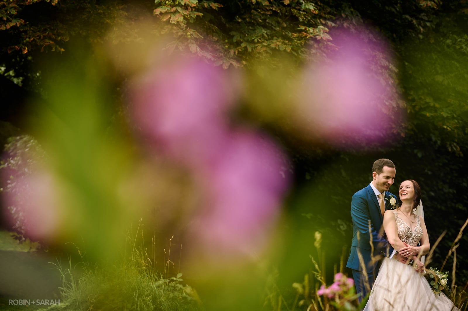 Bride and groom together in beautiful lush gardens