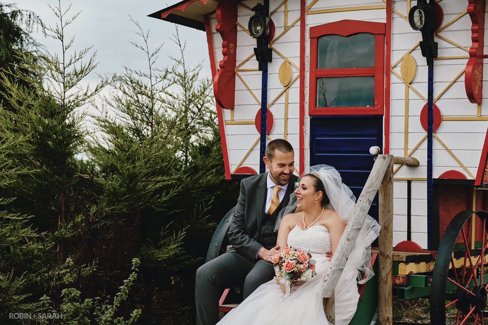 Bride and groom sitting on steps of Gypsy Wagon at The Barn at Dinthill