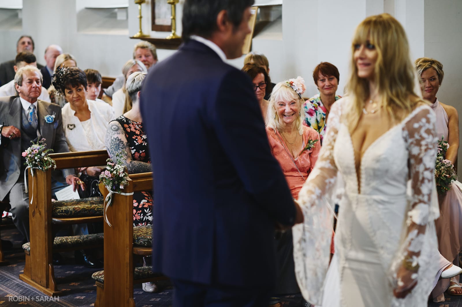 Family watch as bride and groom exchange wedding vows