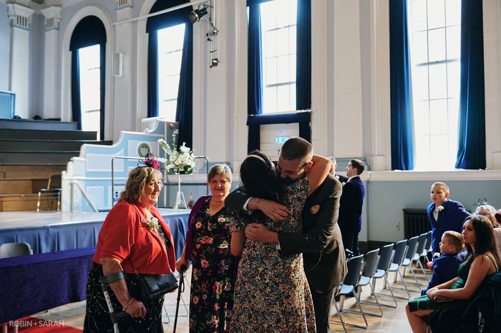 Groom hugs wedding guests as they arrive for ceremony at Kidderminster Town Hall