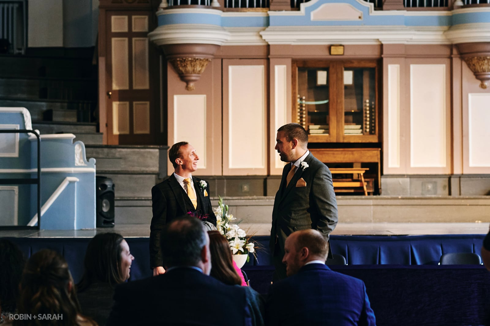 Groom and friend chat as wedding guests arrive at Kidderminster Town Hall