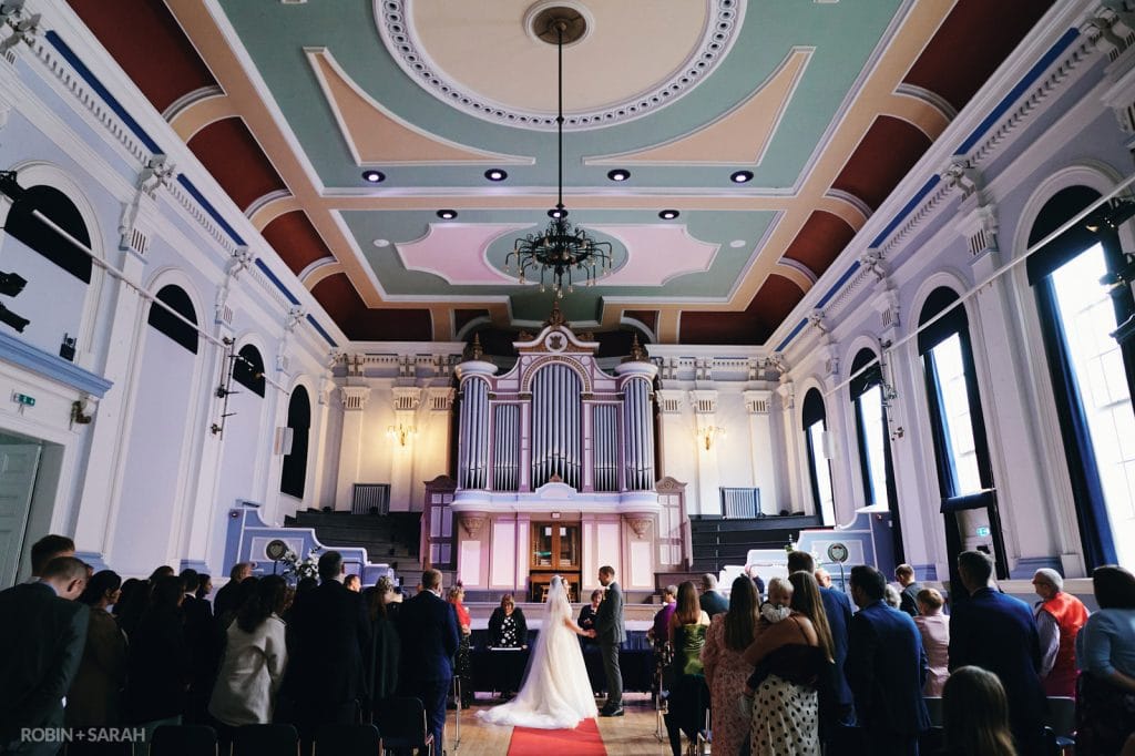Bride and groom hold hands as they exchange wedding vows in Kidderminster Town Hall