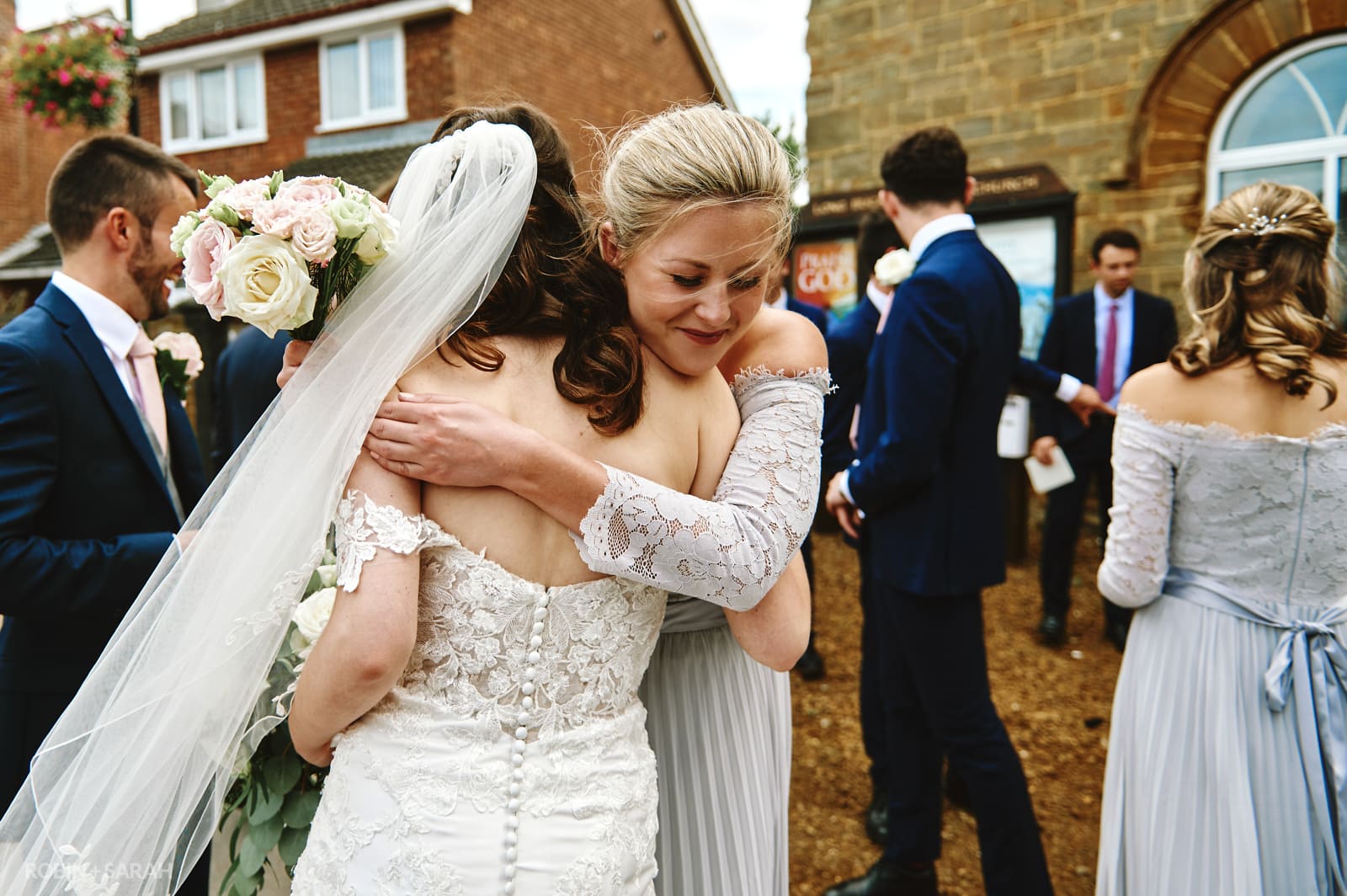 Bride hugs friend after church wedding ceremony