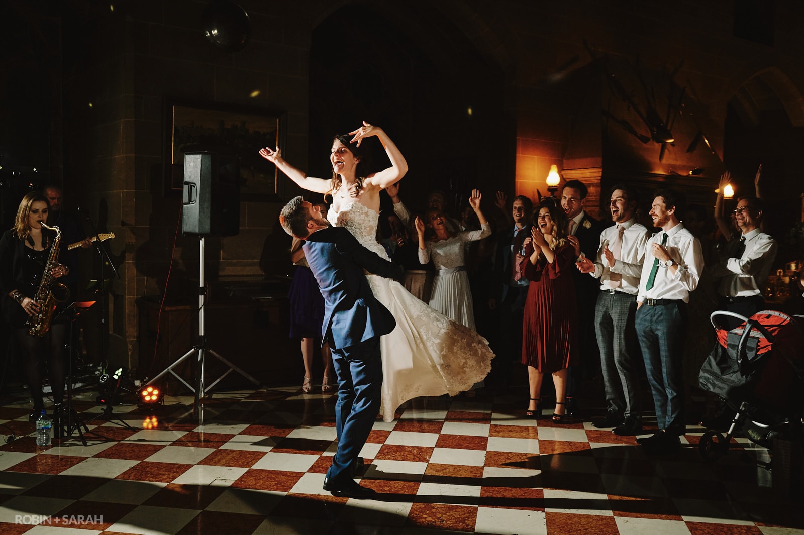 Groom lifts up bride during first dance