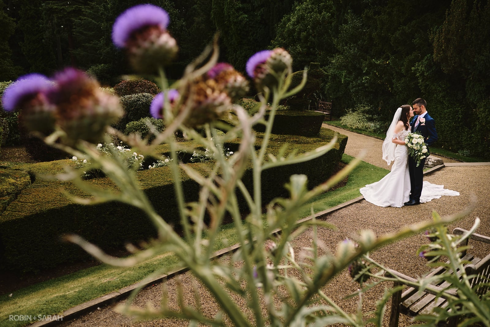 Bride and groom together in beautiful gardens at Warwick Castle