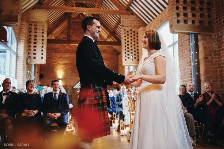 Bride and groom exchange wedding vows in beautiful barn