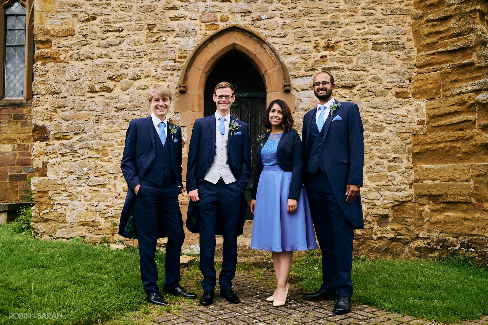 Group photo of groom and friends outside old church