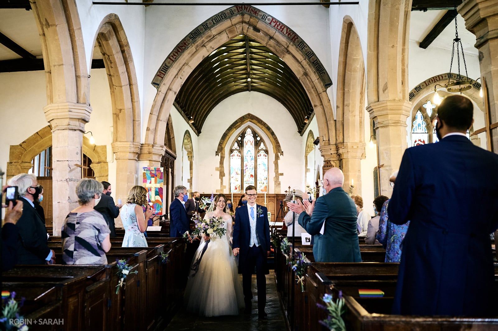 Bride and groom walk down aisle after wedding ceremony at St Faiths church Kilsby
