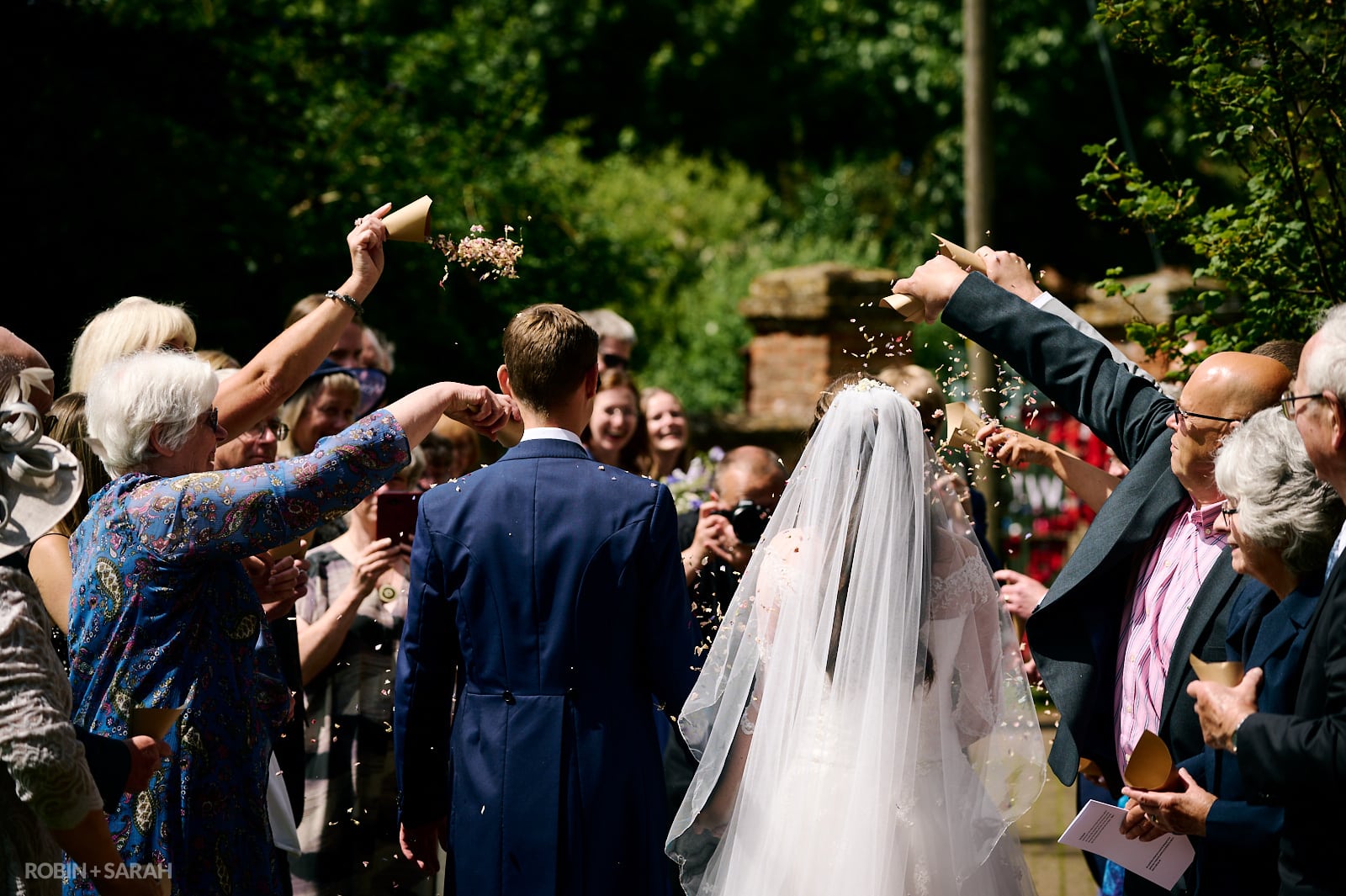 Bride and groom walk through confetti throw