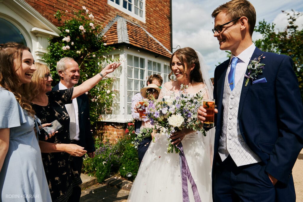 Bride and groom chat to guests as they arrive at wedding reception