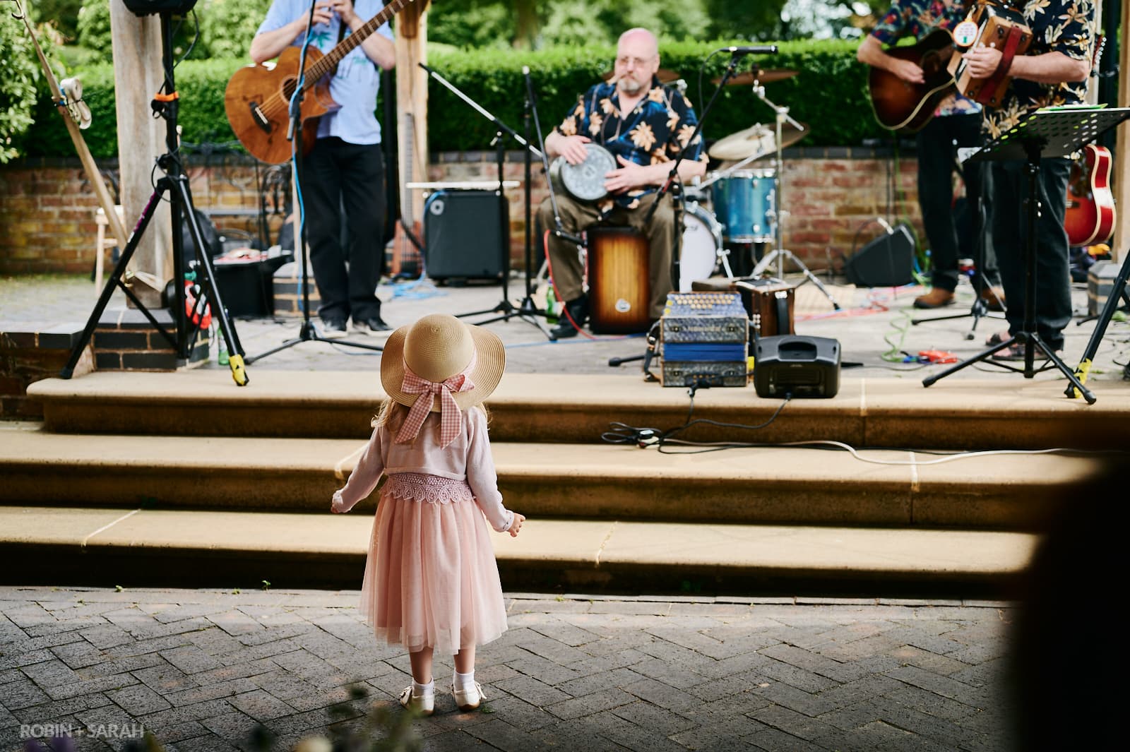Young girl watches musicians play at wedding reception