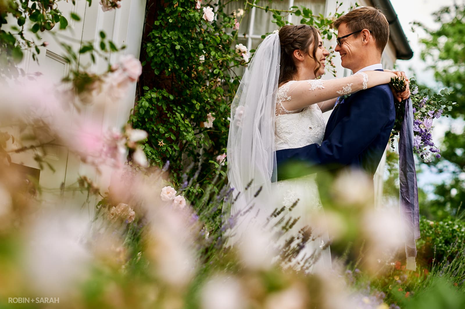 Bride and groom at Wethele Manor surrounded by summer flowers